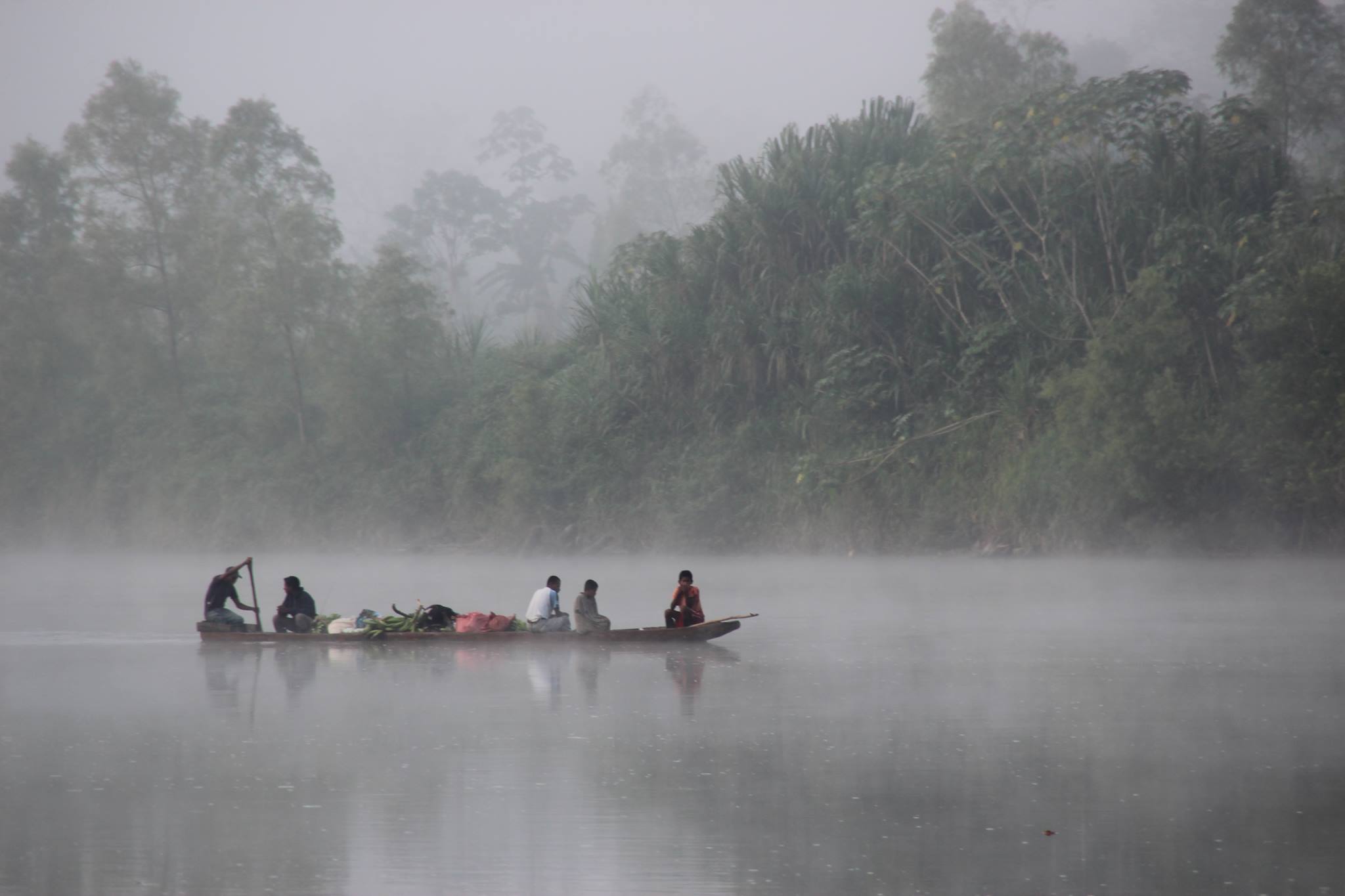 Csónakázó emberek a ködös folyóban